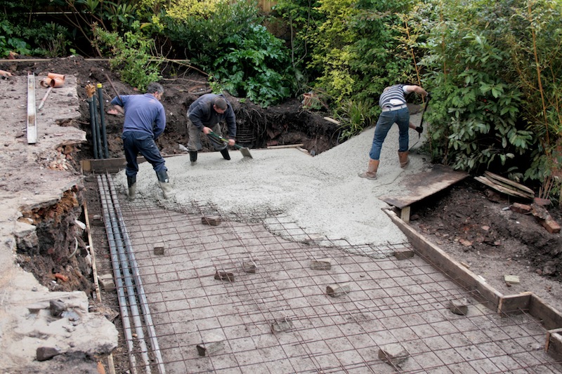 Pouring the concrete for the koi pond base