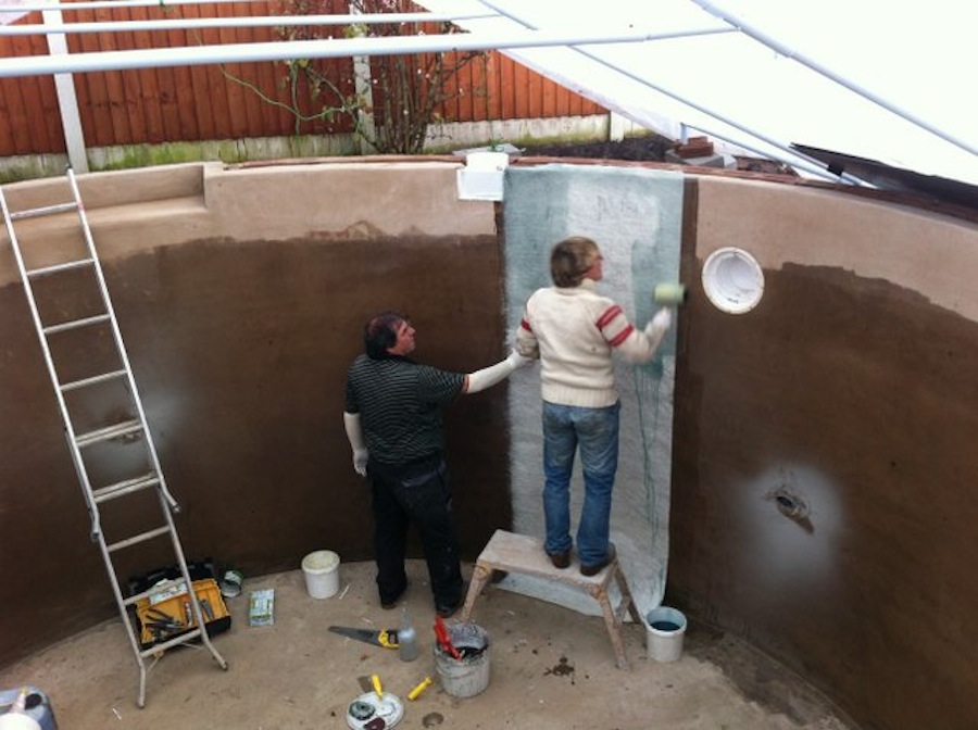 Workmen fiberglassing the koi pond